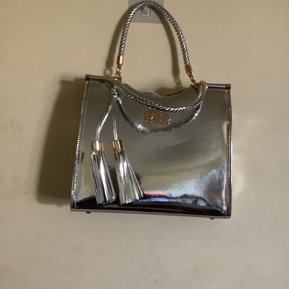 Silver faux leather handbag by Bebe Los Angeles. 12” length X 11” high.